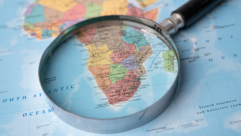Photo of an African map with a magnifying glass over it