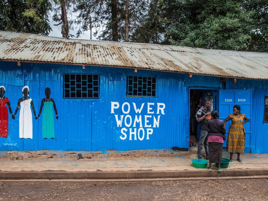Photo of a community building with the words "Power Women Shop" on the outside wall