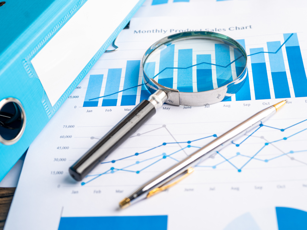 Photo of data graph and magnifying glass and pen