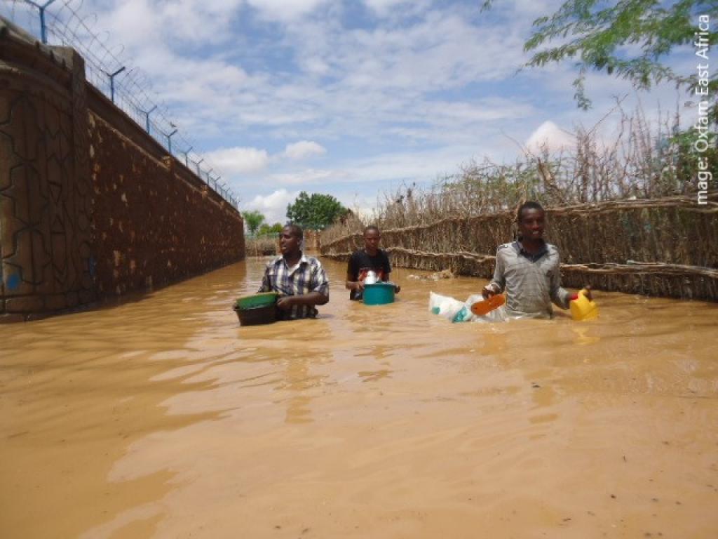 A photo of flooding people walking waste deep in water during flooding in Somalia, East Africa