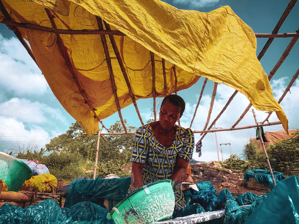 African woman working under a make-shift shelter